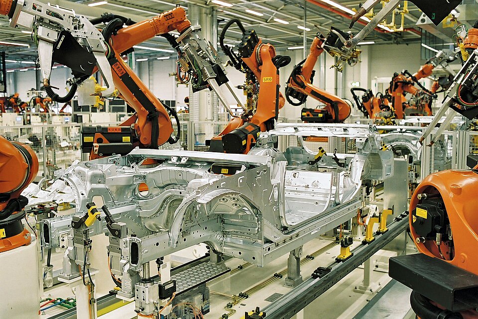 6-axis articulated KUKA robots spot-welding car bodies on a BMW assembly line