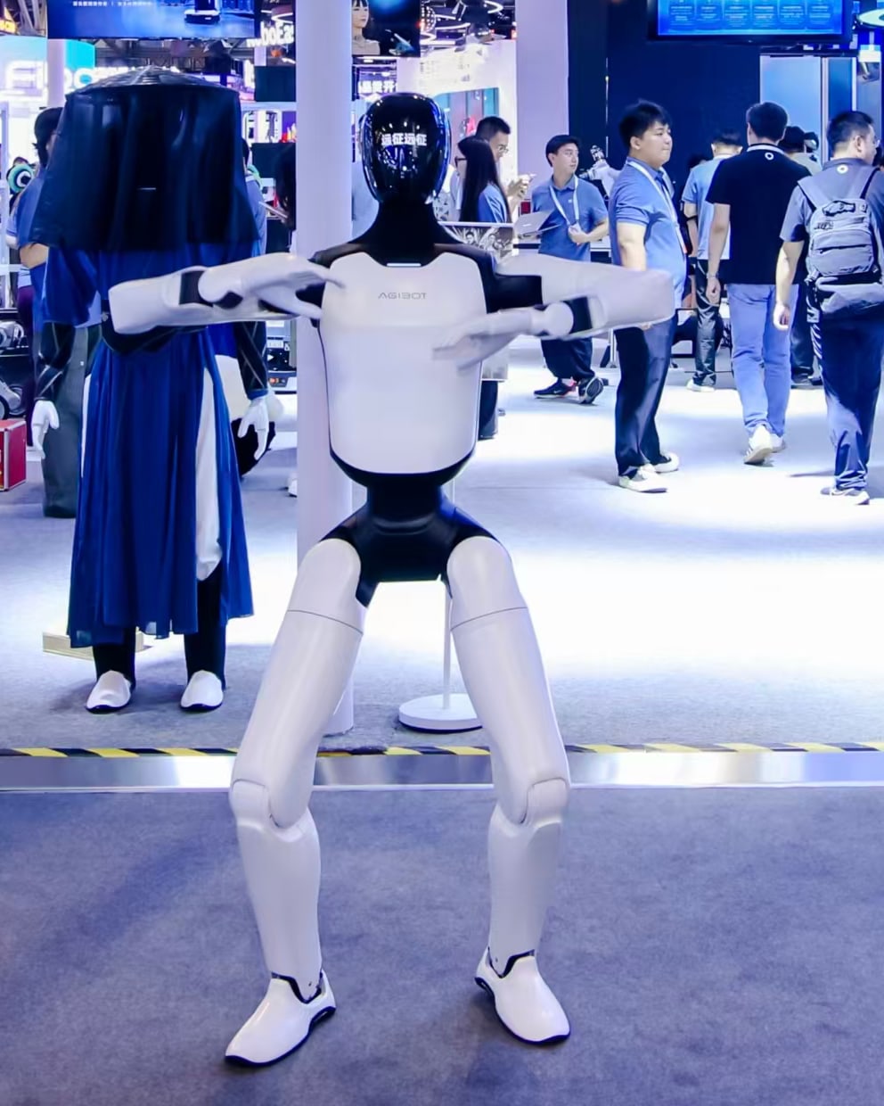 AgiBot A3 Ultra standing with arms extended at AgiBot's WAIC 2026 booth in Shanghai — photo from AgiBot's official press release